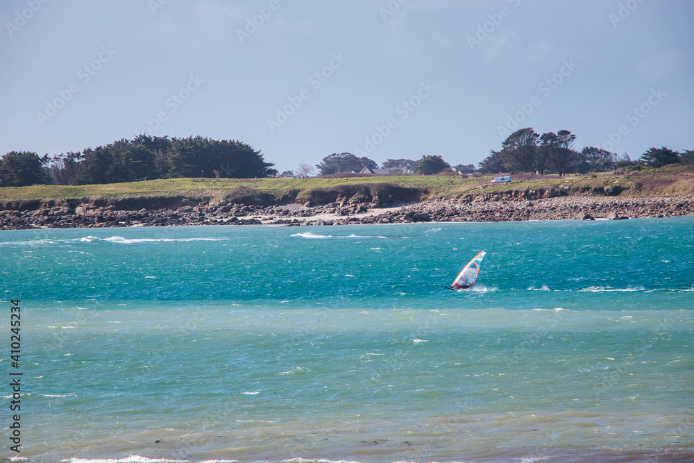 A windsurfer enjoying the beautiful scenery of the coast of Ploudalmezeau, Finistere, Bretagne, France