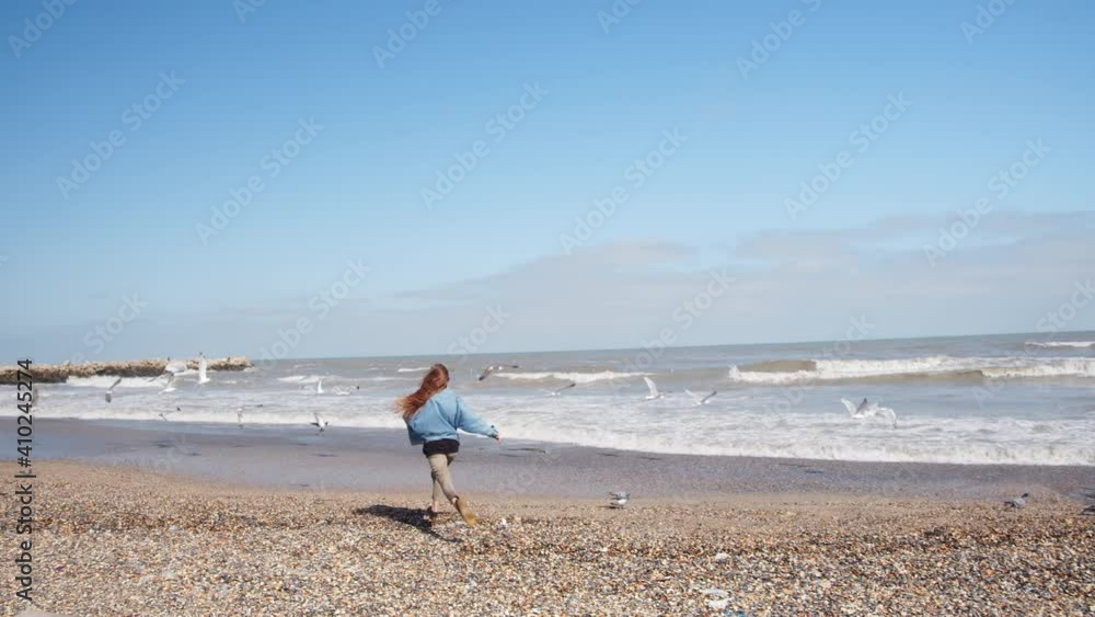 lovely girl scares the seagulls on the beach lovely girl scares the seagulls on the beach