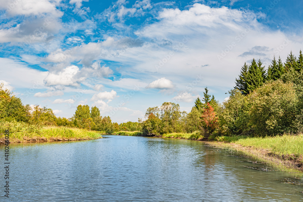 Panoramic landscape on a sunny day on the river with the sky in the clouds and the reflection in the water. Panoramic landscape on a sunny day on the river with the sky in the clouds and the reflection in the water.
