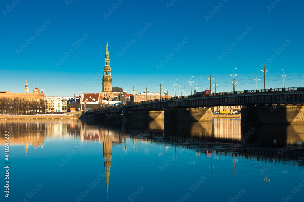 riga. in the photo, a panorama of the city and a stone bridge against the blue sky