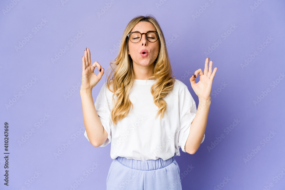 Young caucasian blonde woman relaxes after hard working day, she is performing yoga. Young caucasian blonde woman relaxes after hard working day, she is performing yoga.