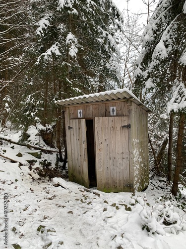 Country toilet in the winter outdoors. Outdoor toilet construction. Cabin - Toilet in the forest on the snow. photo