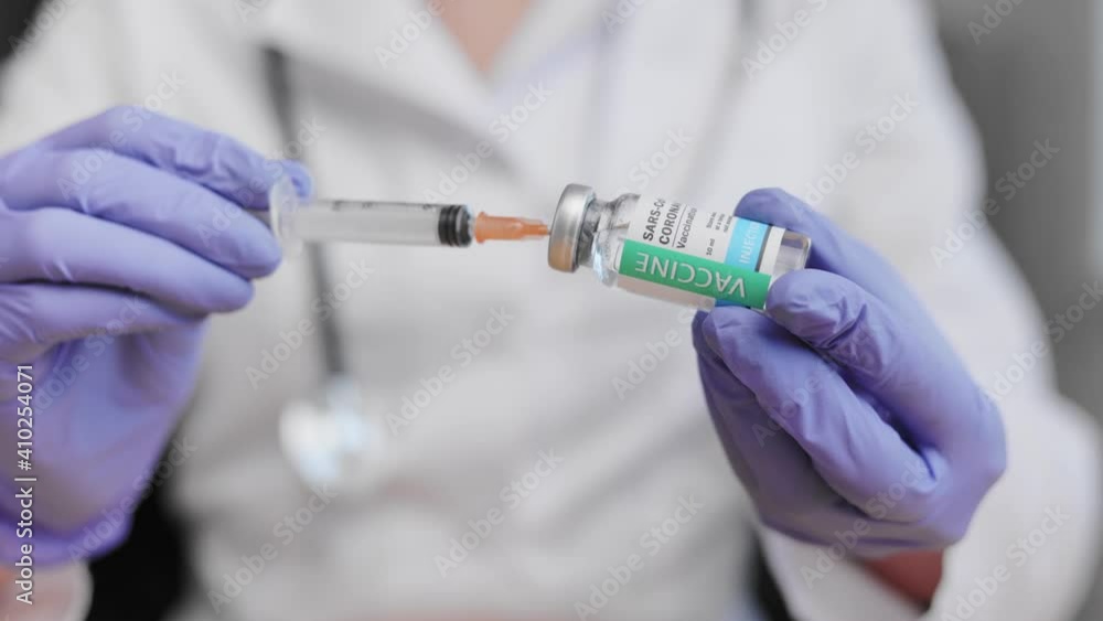 Process of vaccine development, experimental researches in medical laboratory. Health and medical concepts. Close-up of doctors hands holding syringe with transparent solution and infusing in ampoul. Process of vaccine development, experimental researches in medical laboratory. Health and medical concepts. Close-up of doctors hands holding syringe with transparent solution and infusing in ampoul.