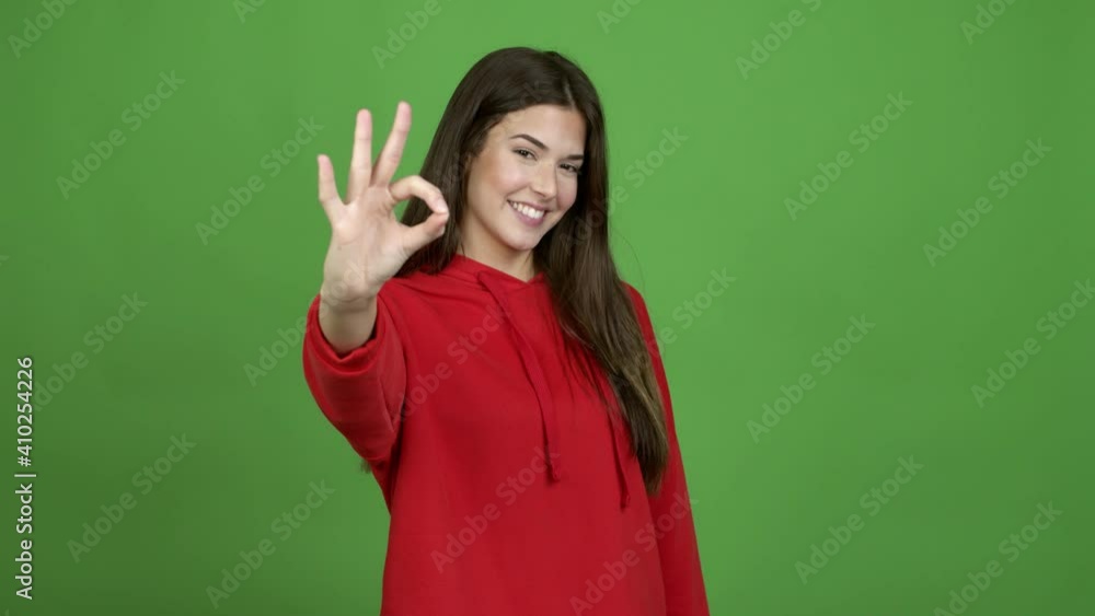 Teenager Brazilian girl showing ok sign with fingers over isolated background. Green screen chroma key video Teenager Brazilian girl showing ok sign with fingers over isolated background. Green screen chroma key video
