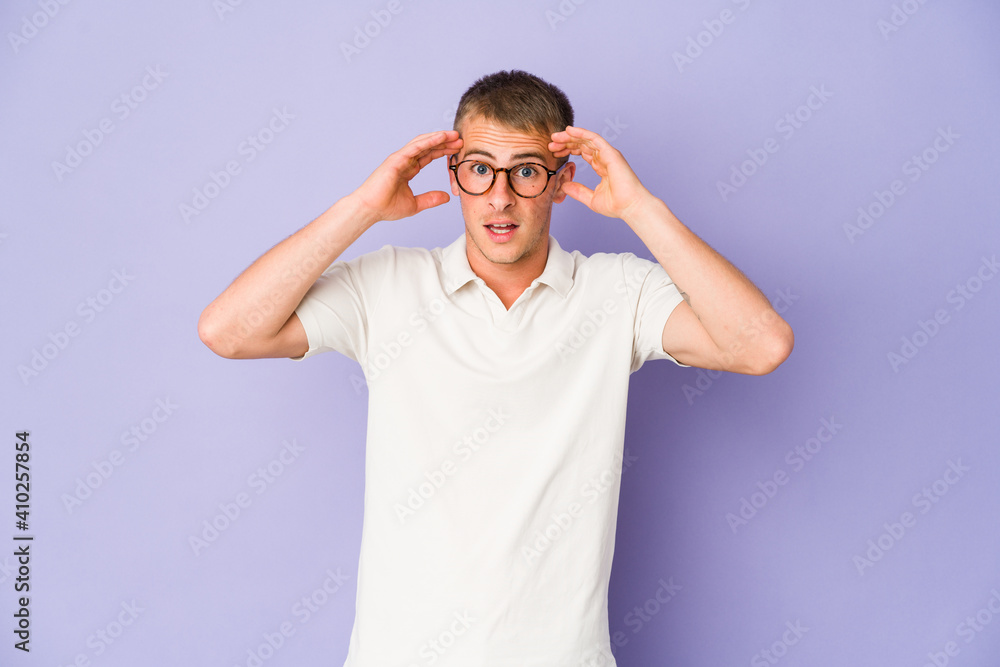 Fototapeta premium Young caucasian handsome man receiving a pleasant surprise, excited and raising hands.