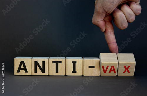 Anti-vax symbol. Doctor turns cubes with words 'anti-vax'. Beautiful grey background. Copy space. Business, medical covid-19 vaccination or anti-vax concept. photo