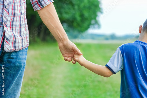 beautiful hands of parent and child outdoors in the park