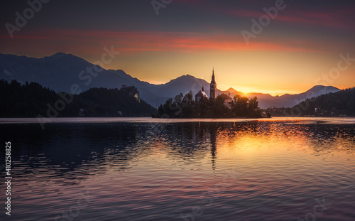 Little Island with Catholic Church in Bled Lake, Slovenia  at Sunrise with Castle and Mountains in Background