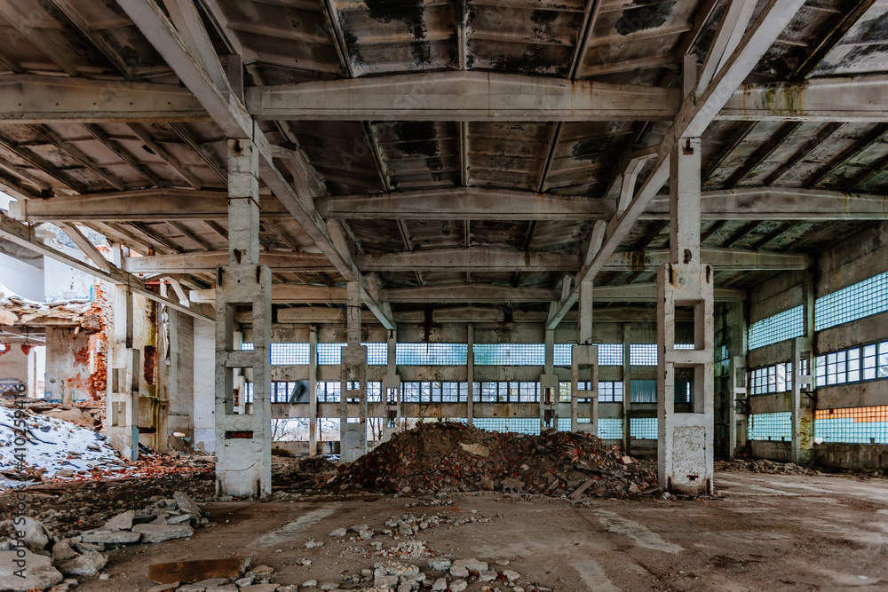Abandoned ruined large industrial hall with garbage waiting for demolition