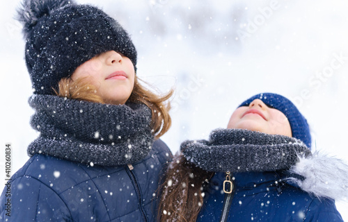 child girl playing with snow in winter outdoor and having fun on snowy winter