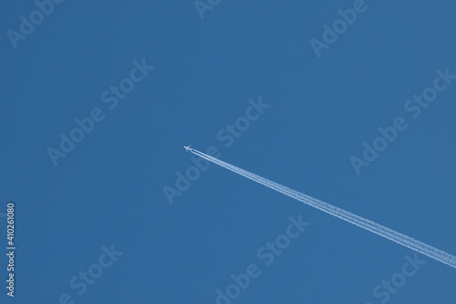 Image of an airplane crossing the sky leaving a white trail