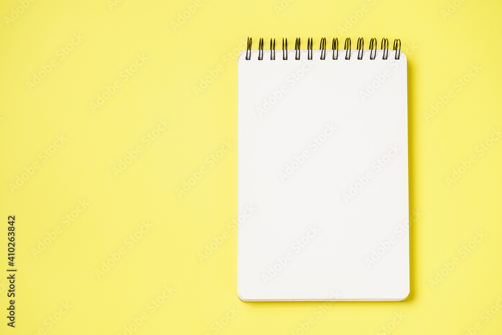 School notebook on a paper yellow background, spiral notepad and craft cardboard pen School notebook on a paper yellow background, spiral notepad and craft cardboard pen