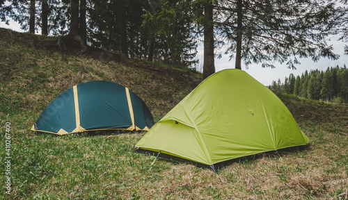 Green tents in a clearing, camping in the woods, adventure
