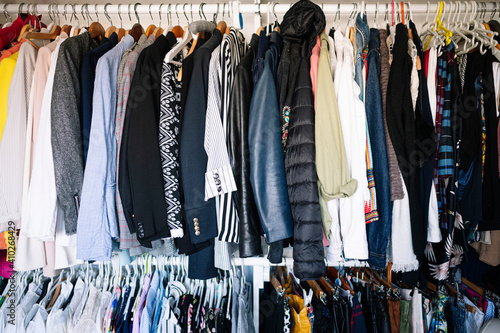 Variation of clothes hanging on rack in wardrobe at apartment photo