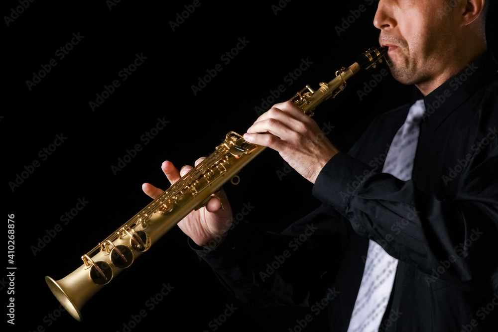 Fototapeta premium soprano saxophone in the hands of a guy on a black background