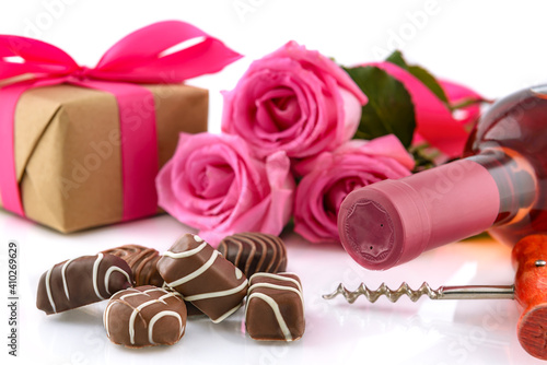 Fotografie Chocolate pralines, wine bottle, roses and gift