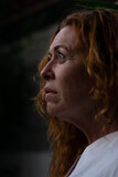red-haired woman 50 years old in white T-shirt with a very sensitive and relaxing face.
