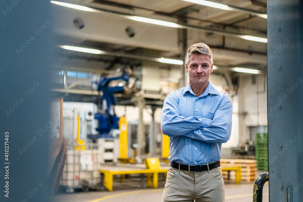 Confident manager with arms crossed standing in industry Confident manager with arms crossed standing in industry