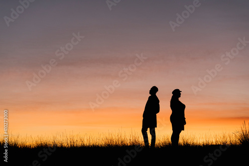In silhouette of man and woman standing against sky © Ezequiel Gim√©nez/Westend61