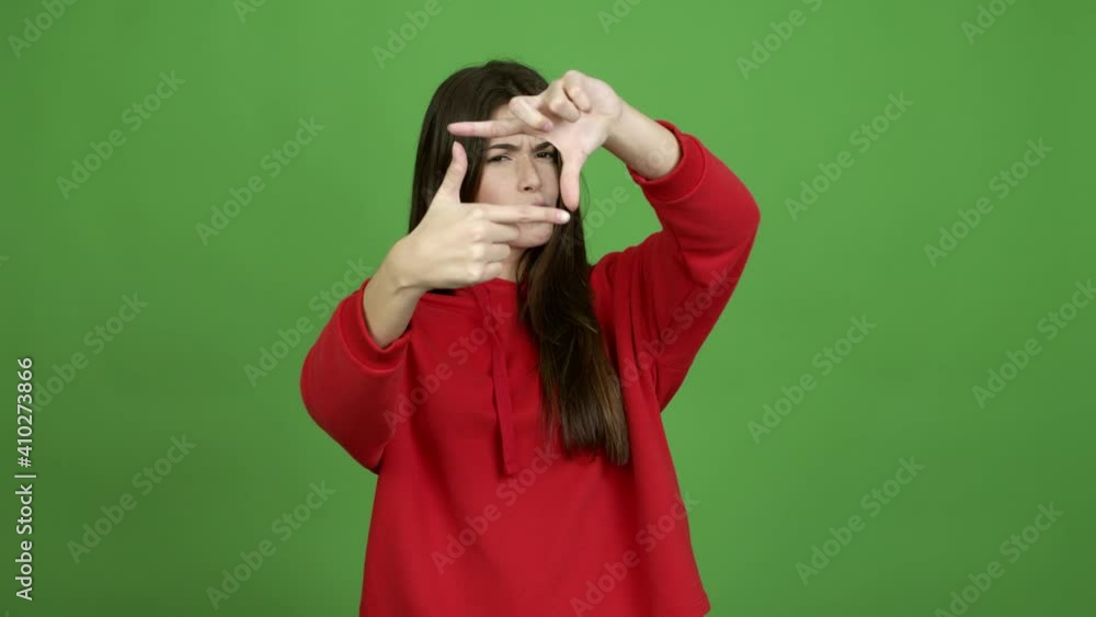 Teenager Brazilian girl focusing with fingers over isolated background. Green screen chroma key video Teenager Brazilian girl focusing with fingers over isolated background. Green screen chroma key video