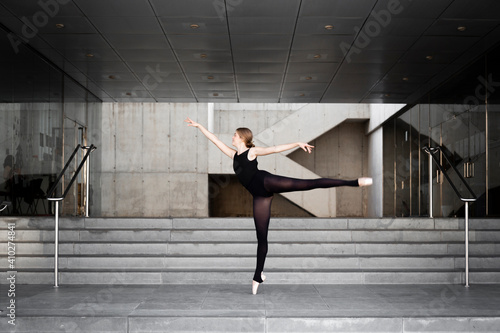 Ballerina in black leotard in modern concrete building