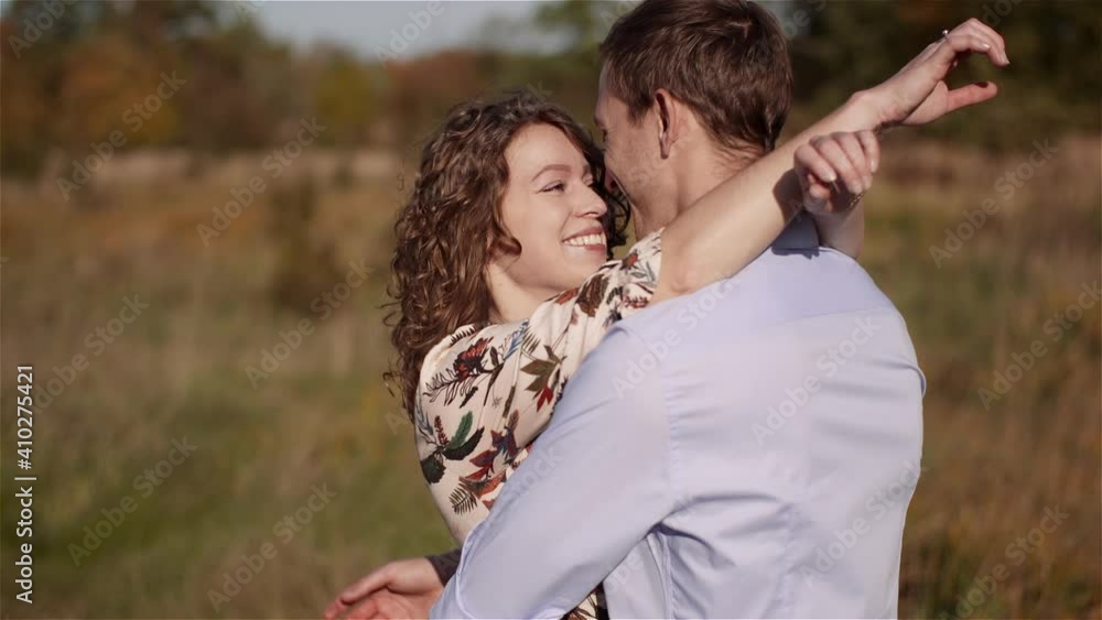 Young Couple Walking on a Meadow. Positive Young Poeple Happieness.