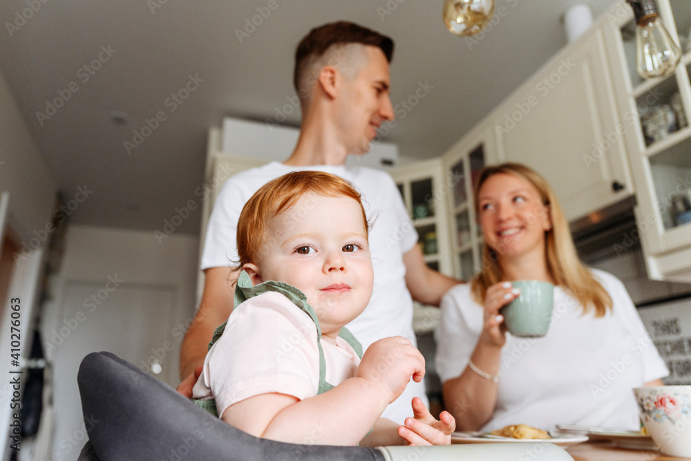 Happy family with baby daughter at kitchen table Happy family with baby daughter at kitchen table