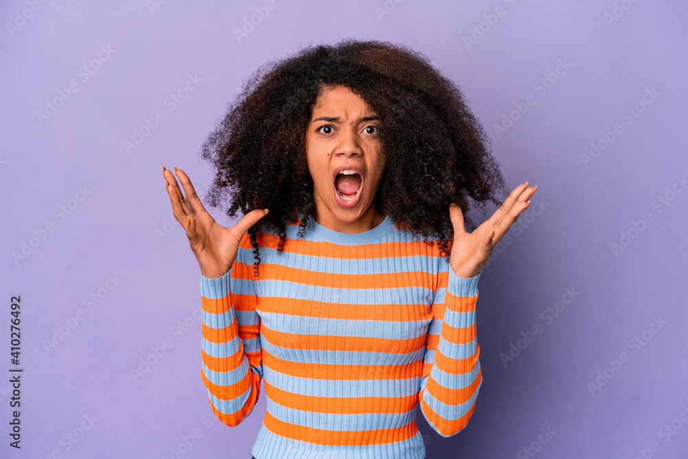 Young african american curly woman isolated on purple background screaming to the sky, looking up, frustrated. Young african american curly woman isolated on purple background screaming to the sky, looking up, frustrated.