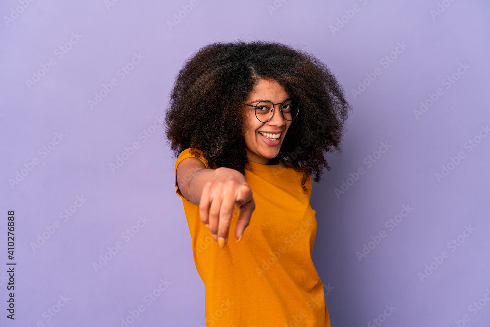 Young african american curly woman isolated on purple background cheerful smiles pointing to front. Young african american curly woman isolated on purple background cheerful smiles pointing to front.