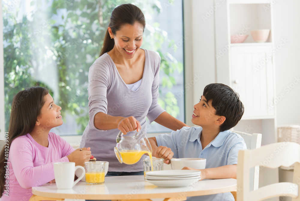 Mother with son (12-13) and daughter (10-11) having breakfast Mother with son (12-13) and daughter (10-11) having breakfast