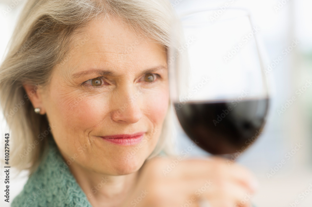 Senior female connoisseur tasting red wine Senior female connoisseur tasting red wine