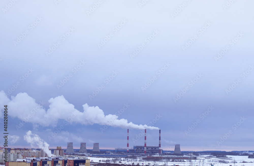 smoke from the pipes of heating station, pollution and environment, winter cityscape and ecology