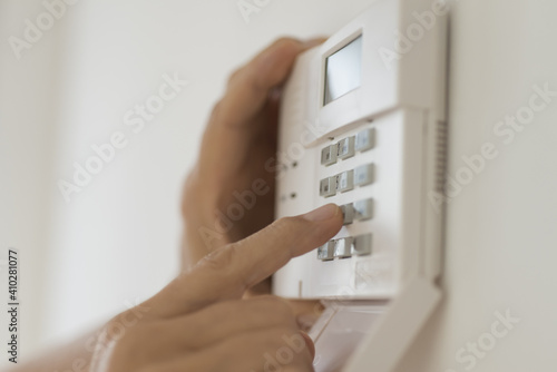 Hand setting code on burglar alarm photo