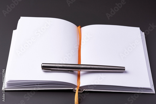 An open notebook with an ink pen on a dark background