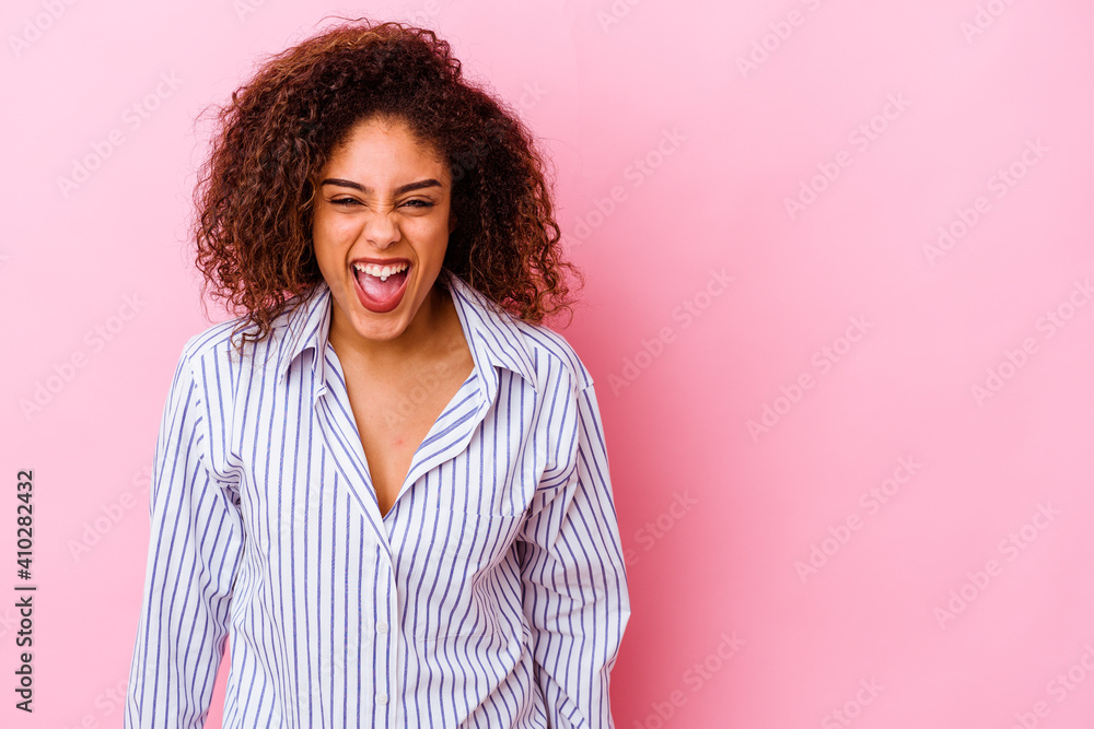 Fototapeta premium Young african american woman isolated on pink background shouting very angry, rage concept, frustrated.
