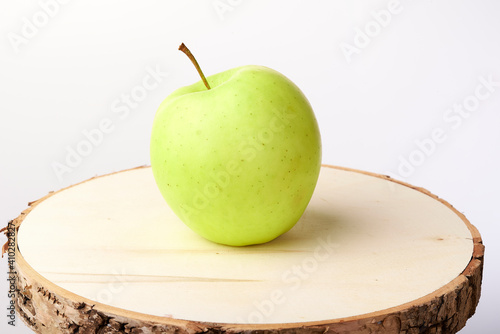 Green apple on a wooden stand