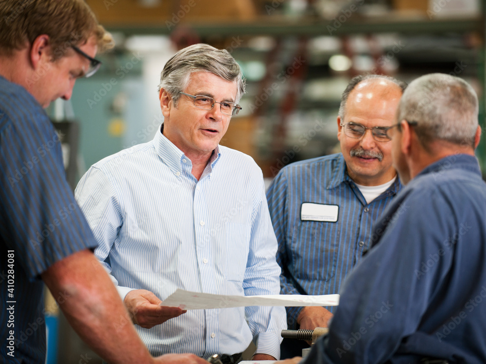 Businessman and workers talking in factory Businessman and workers talking in factory