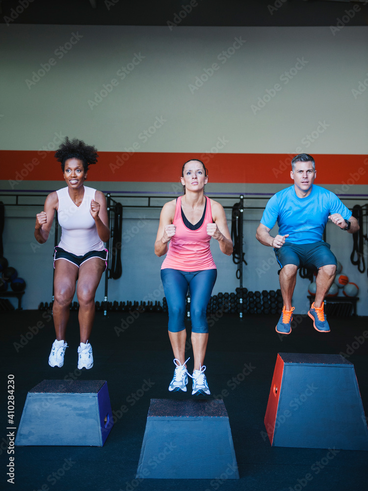 © Erik Isakson/Tetra Images - Three people in step aerobics class