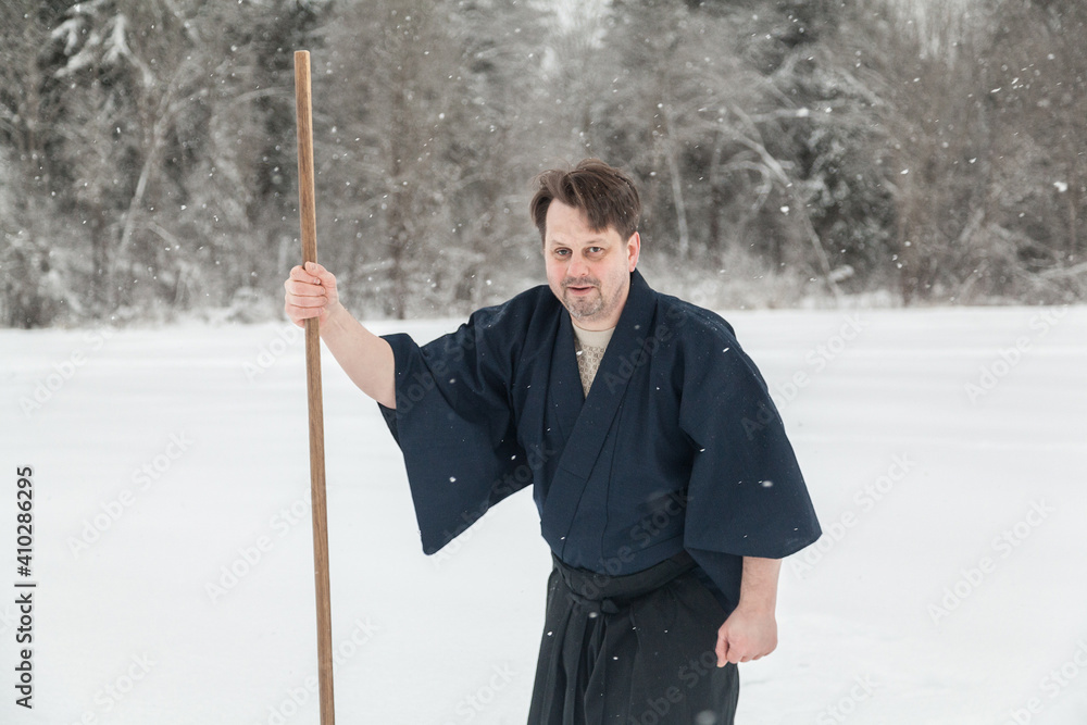 samurai warrior walks with sword and staff across an empty winter field samurai warrior walks with sword and staff across an empty winter field