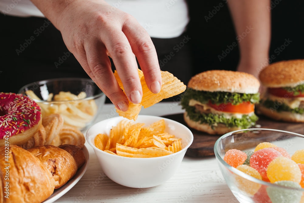 Woman eating unhealthy food, compulsive overeating Woman eating unhealthy food, compulsive overeating