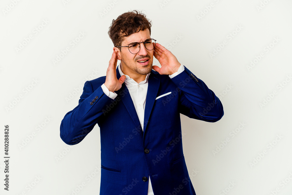 Young business caucasian man isolated on white background covering ears with fingers, stressed and desperate by a loudly ambient. Young business caucasian man isolated on white background covering ears with fingers, stressed and desperate by a loudly ambient.