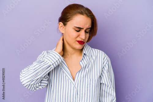 Young arab mixed race woman having a neck pain due to stress, massaging and touching it with hand.