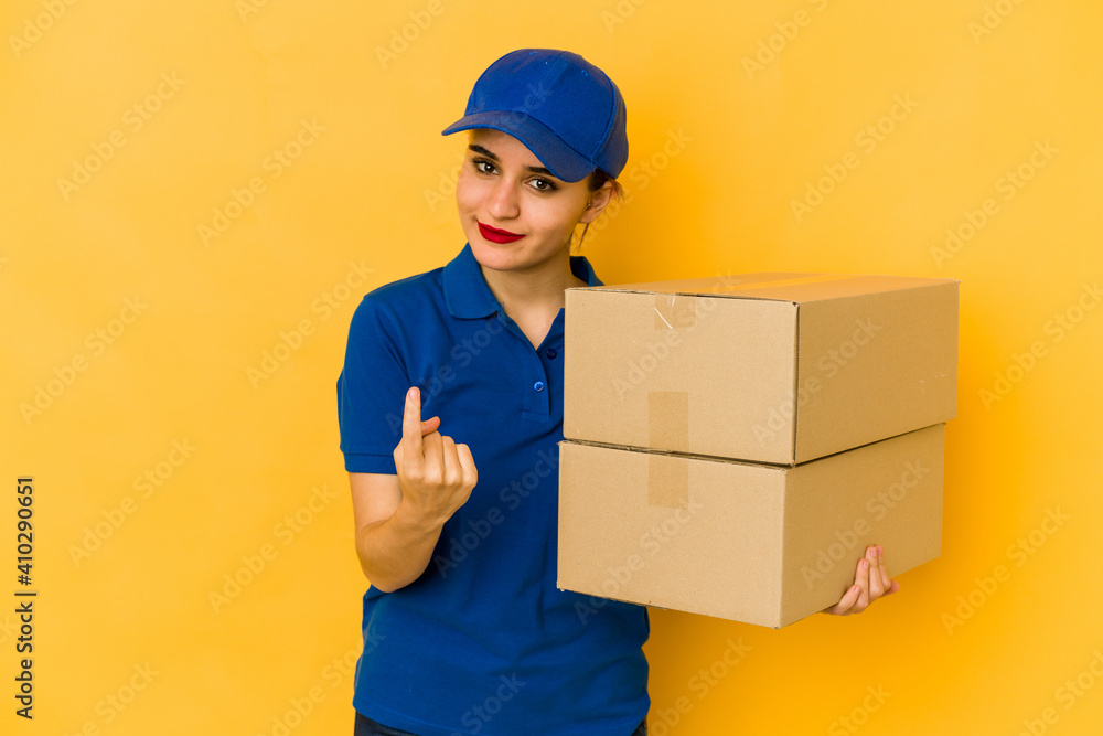 Young skinny delivery arab girl pointing with finger at you as if inviting come closer. Young skinny delivery arab girl pointing with finger at you as if inviting come closer.