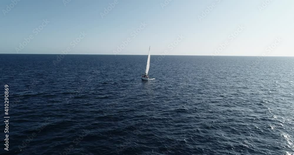 Sailboat sailing in the middle of the Sea. We can see the boat and the water all over the horizon - aerial view with a drone 4K Sailboat sailing in the middle of the Sea. We can see the boat and the water all over the horizon - aerial view with a drone 4K