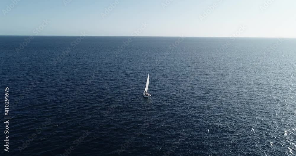 Aerial view with a drone of a sailboat sailing in the middle of the Mediterranean Sea under the blue sky. Perfect for leisure activity in travel and holidays 4K Aerial view with a drone of a sailboat sailing in the middle of the Mediterranean Sea under the blue sky. Perfect for leisure activity in travel and holidays 4K