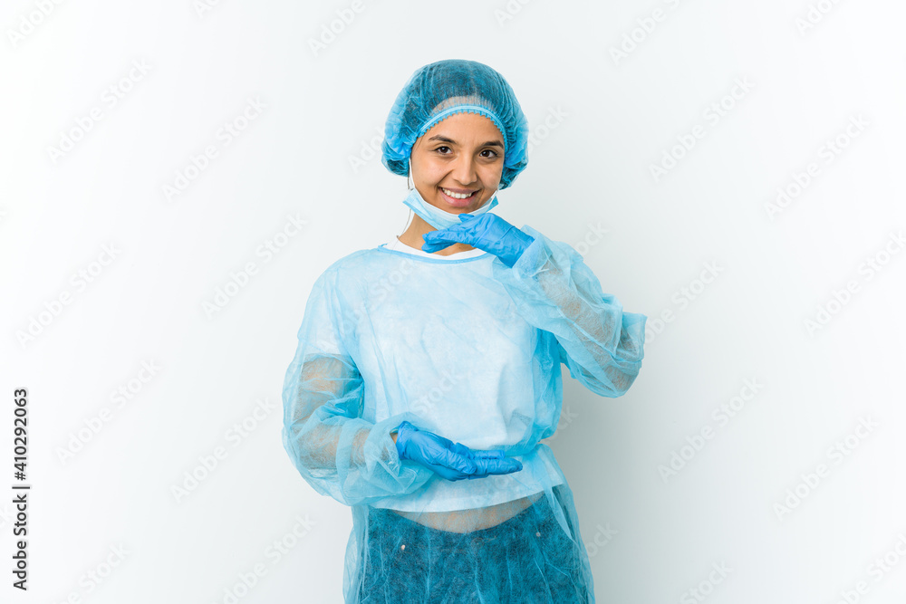 Young surgeon latin woman isolated on white background holding something with both hands, product presentation. Young surgeon latin woman isolated on white background holding something with both hands, product presentation.