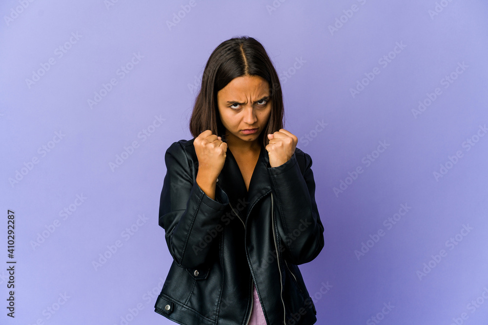 Young mixed race woman throwing a punch, anger, fighting due to an argument, boxing. Young mixed race woman throwing a punch, anger, fighting due to an argument, boxing.