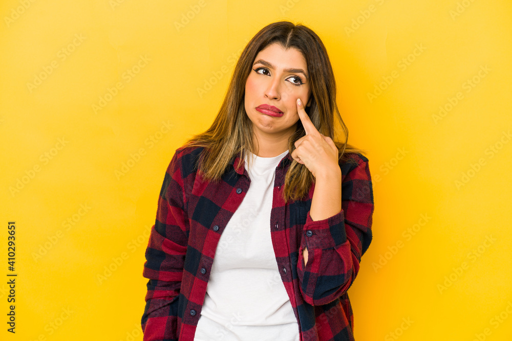 Young indian woman isolated on yellow background crying, unhappy with something, agony and confusion concept. Young indian woman isolated on yellow background crying, unhappy with something, agony and confusion concept.