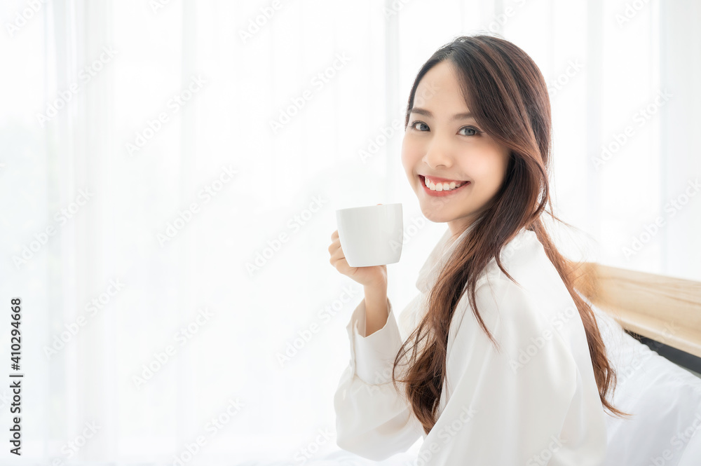 Young asian woman sitting on bed at home and drinking milk after wake up in the morning Young asian woman sitting on bed at home and drinking milk after wake up in the morning