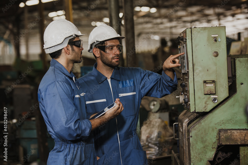 Two people working. Male Industrial Engineers Talk with Factory Worker while Using tablet. Two people working. Male Industrial Engineers Talk with Factory Worker while Using tablet.